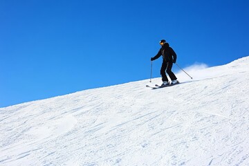 A lone skier on a snowy mountain slope, crisp blue sky, fresh powder, exhilarating winter sports scene