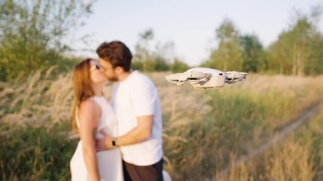 Couple hug and kiss in countryside meadow while drone hover and film, Czechia