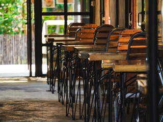 Empty cafe interior in the morning. Wooden tables and elegant wooden chairs in the restaurant.