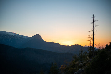 Obraz premium The sunset atop Mount Kopieniec in Zakopane, Poland, casts a warm glow over the Tatra Mountains