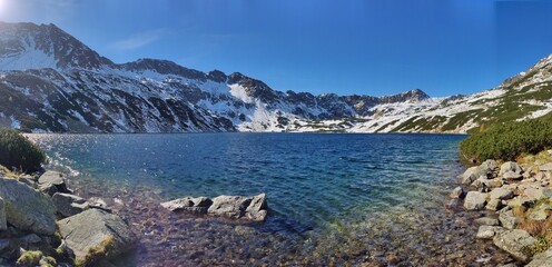 Morskie Oko Lake in the Tatra Mountains, Zakopane, Poland, captivates with its clear emerald waters and stunning mountain backdrop, offering a peaceful escape in nature. © Yunona