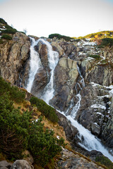 The Wielka Siklawa waterfall in the Valley of Five Ponds, Tatra Mountains, Zakopane, Poland, cascades dramatically over rocky cliffs, creating a mesmerizing scene in this alpine landscape.