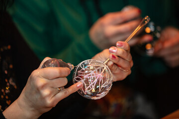 woman hands decorating glass christmas tree ball,