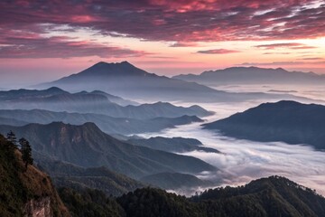 Obraz premium A majestic mountain range at dawn, with misty clouds and a maroon-colored sunrise, mountain range, natural scenery, geography, hillside