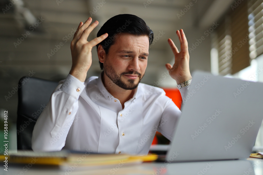 Aufkleber a man is sitting at a desk with a laptop in front of him. he is angry and frustrated, possibly due t