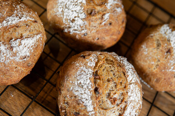 Classic farm country bread buns on a grill. These homemade rustic rolls balls are made of organic wholemeal multigrain wheat flour for a sourdough recipe.