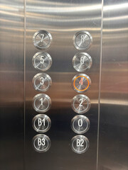 A silver elevator with a red circle on the number 4