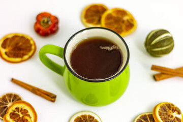 close up green tea mug and dry lemon with cinnamon on white table