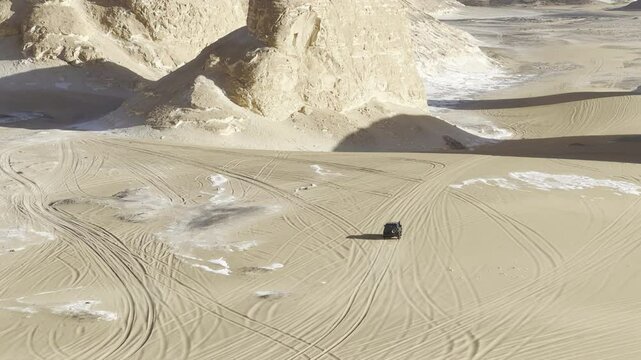 The Egyptian white desert adventure tourism with bedouin camping and 4x4 driving through the desert to see rock formation and sand and dust at sunset and golden hour
