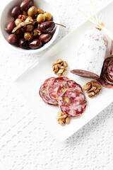 Sliced french salami on white background. Copy space.	