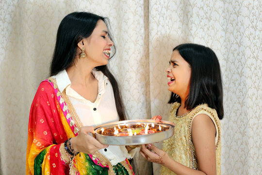Sharing laughter and light, making Diwali moments unforgettable. A playful moment of joy and warmth this Diwali. Lighting up Diwali with smiles and laughter.