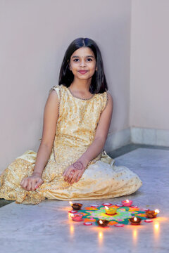 A joyful celebration as she lights diyas, embracing the warmth and spirit of the festival.A radiant smile and glowing diyas capture the joy of the festival.