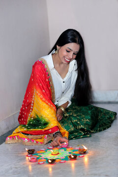 A joyful celebration as she lights diyas, embracing the warmth and spirit of the festival.A radiant smile and glowing diyas capture the joy of the festival.