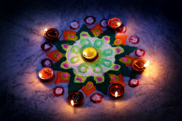 A warm Diwali glow: oil lamps (diyas) encircle a vibrant rangoli, filling the space with light and festive cheer.