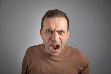 Caucasian young angry man screaming.
