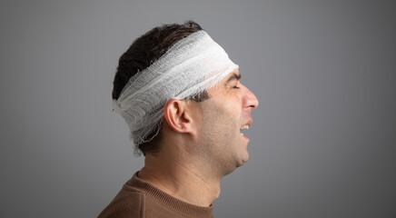 Caucasian man with a bandage on head.