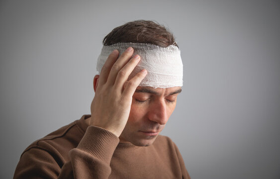 Caucasian man with a bandage on head.