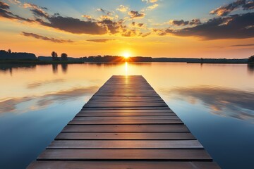 Fototapeta premium A tranquil sunset view captured from a wooden pier, reflecting beautiful colors over serene water near the horizon.