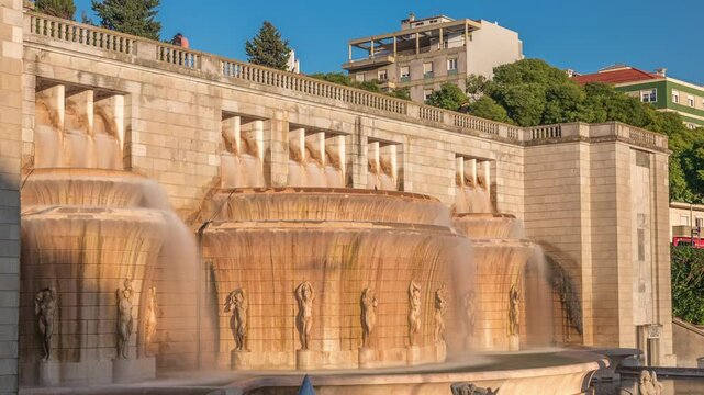 Fonte Luminosa fountain timelapse hyperlapse. Alameda public park in the city center. Residential buildings. It was built to celebrate regular water supply to the eastern part of Lisbon. Portugal.