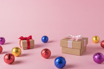 Creative layout of colored candy and gift box on pink background