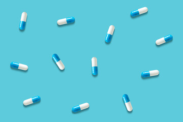 Top view of capsule pills  on blue background. Minimal pharmacy concept.