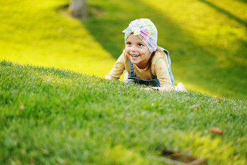 little girl is playing on the grass in the park. Happy time.