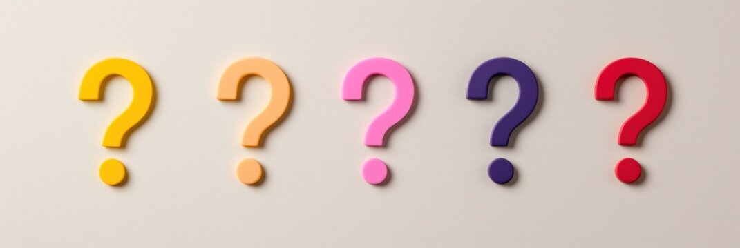 A row of five different colored questions are lined up on a white background. The questions are of different sizes and colors, and they are all pointing in different directions