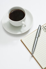 Coffee and a blank notepad with a pen