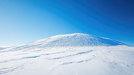 Snowy hill under a clear blue sky in a winter landscape