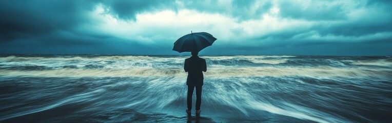 A lone figure on a beach faces dark storm clouds and crashing waves, holding an umbrella as the wind picks up during the evening