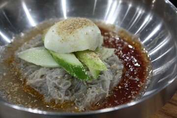 Bibim water naengmyeon with cucumbers and eggs on top
