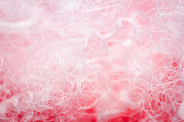 Extreme macro of polyester stable fiber on red background. Selective focus, shallow depth of field. Abstract dreamy background