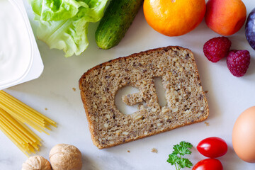 Slice of whole grain bread with symbol GI cut out, products with low glycemic index, creative concept