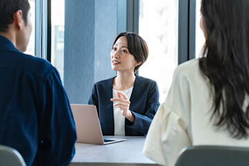 説明をするスーツを着た女性と話を聞くカップル