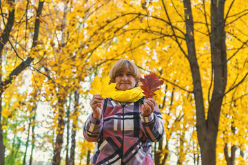 Senior woman in autumn park. Selective focus.