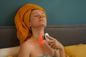 Young woman using infrared massager 