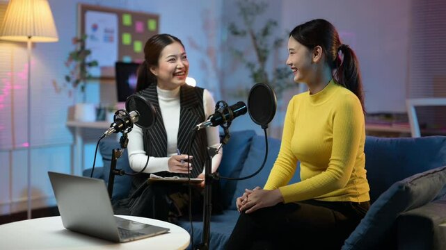 Two asian women discussing during podcast recording session
