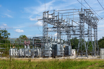 A wide-angle view of an electrical substation framed by a clear blue sky.