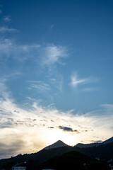 clouds over the mountains on a blue sky background at sunset