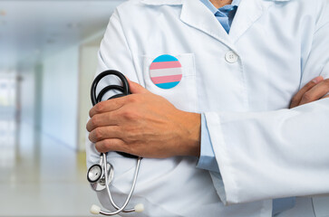 Close-up of heart silhouette with transgender flag of doctor in white coat with stethoscope and...