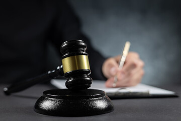 Judge's gavel and papers against judge background