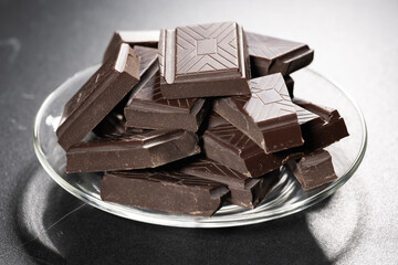 Pieces of dark chocolate on a plate. Bitter chocolate