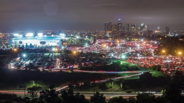 Time Lapse of huge parking lots emptying in Los Angeles at a sporting event. The downtown buildings of LA are in the background. 