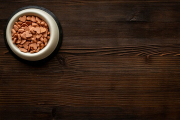 Bowl of biscuits for pets - food in a shape of heart, top view
