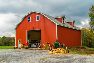 Red barn with pumpkins and vintage tractor