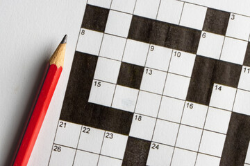 Empty, unfinished crossword puzzle, black and white crossword puzzle with a red pencil. On black background. 