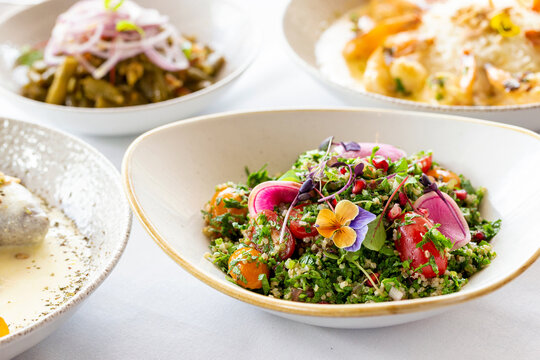 Tabouli quinoa salad topped with edible flowers and red radish.
