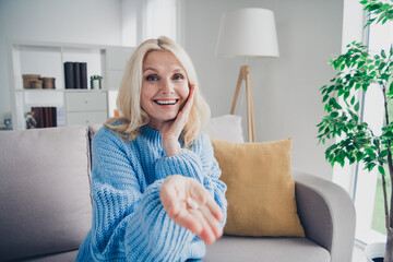 Portrait of nice aged lady sit sofa arm hold pills wear sweater pastime weekend modern flat indoors