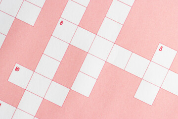 Empty, unfinished crossword puzzle with pink background. 