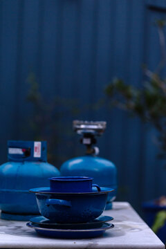 Blue objects on table in front of blue fence